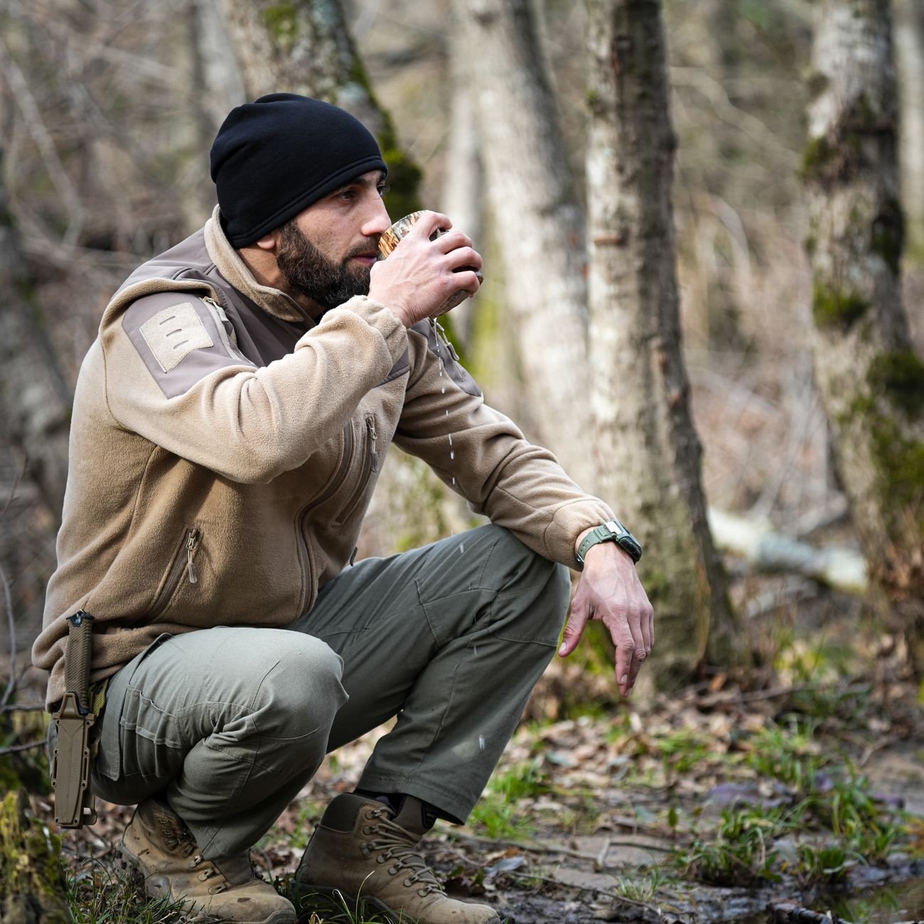 Man wearing camouflage fleece jacket in autumn forest for hunting