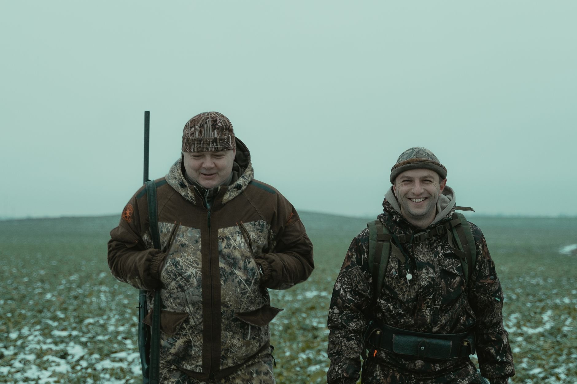 Two hunters in camo gear in winter terrain