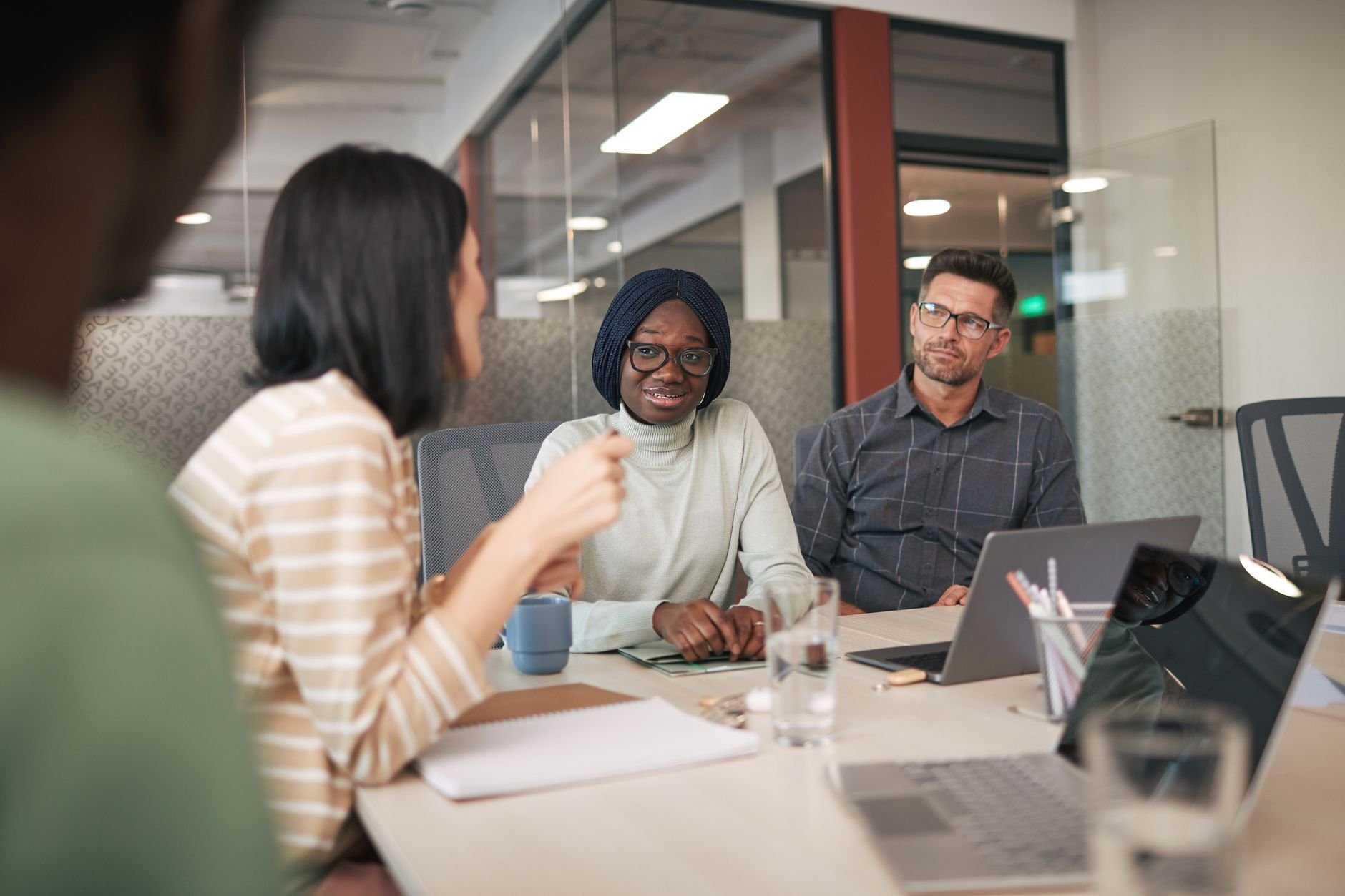 A diverse group of professionals engaged in a business meeting in a modern office setting.