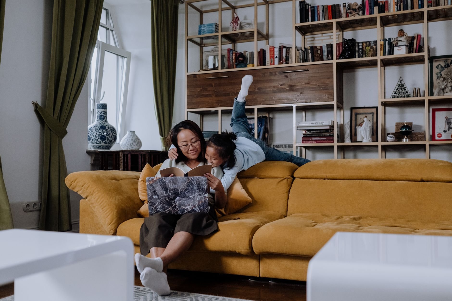 A joyful African American mother and daughter reading together on a cozy sofa — the heart of the homeschool community