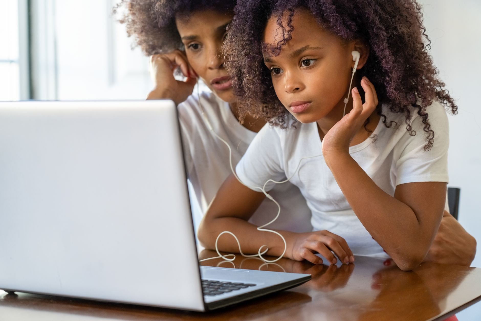 African American mother and daughter using a laptop together — the kind of real educator Schoolhouse Studio builds websites for
