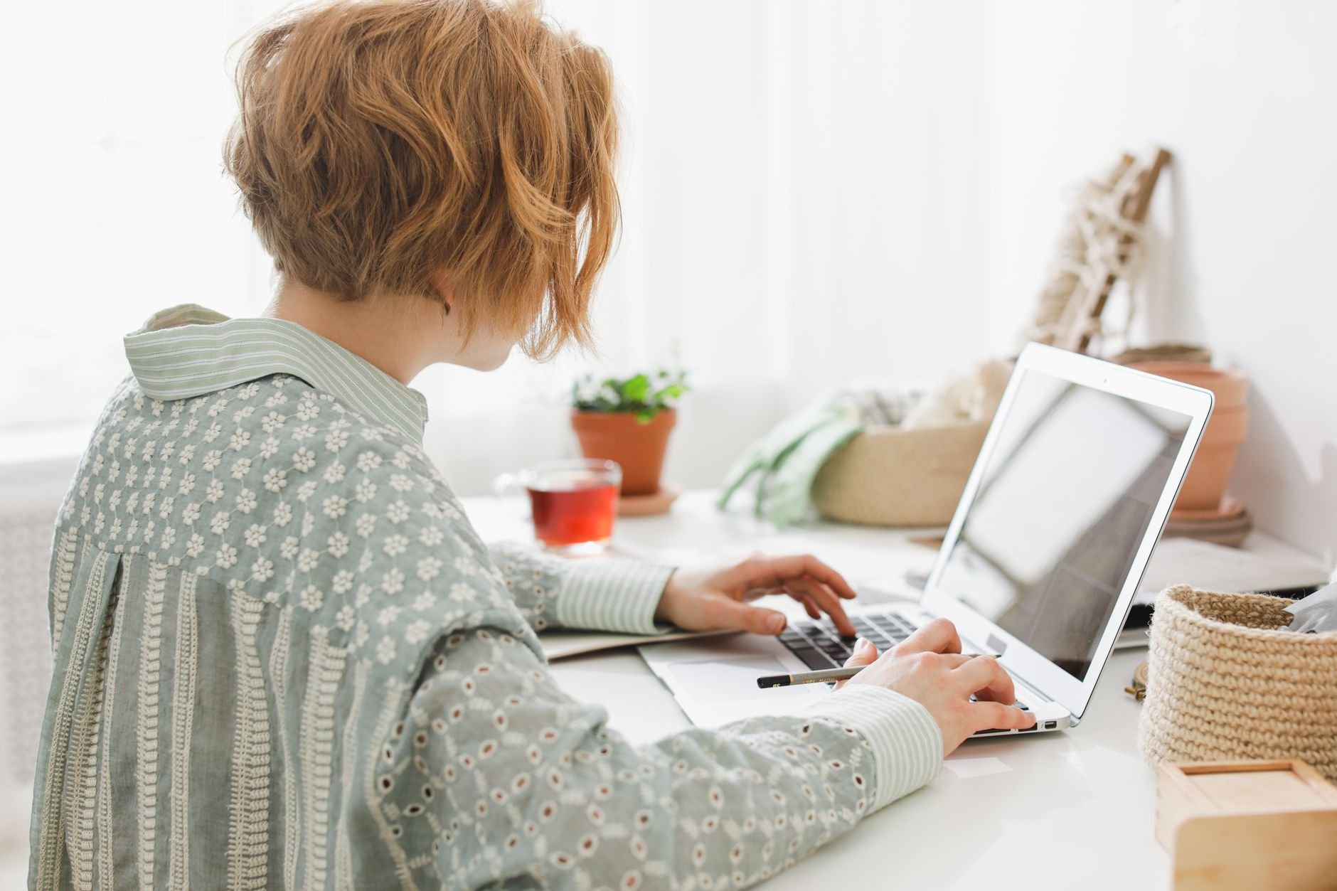 A woman working productively in a bright home office setting.