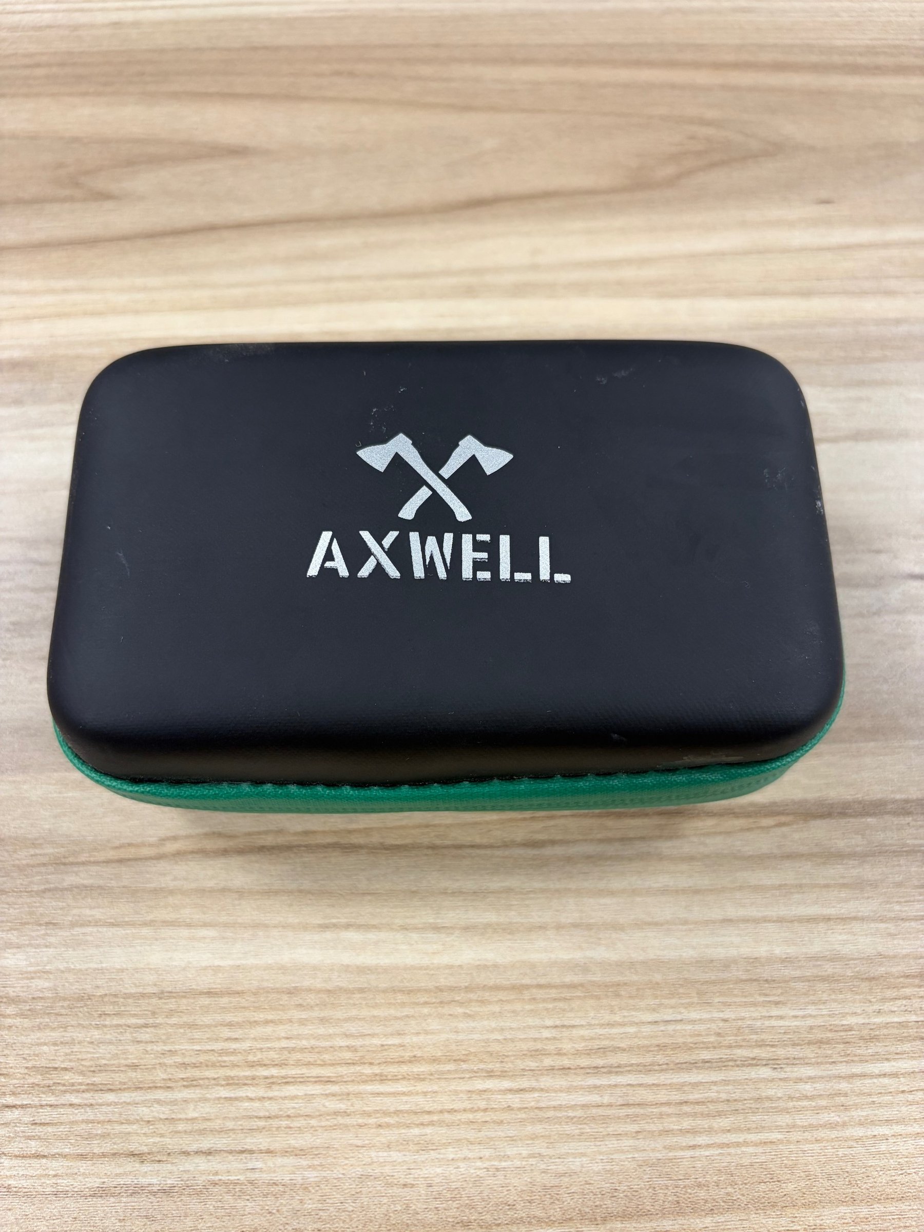 Axwell watch box closed showing brand logo on black case with green zipper
