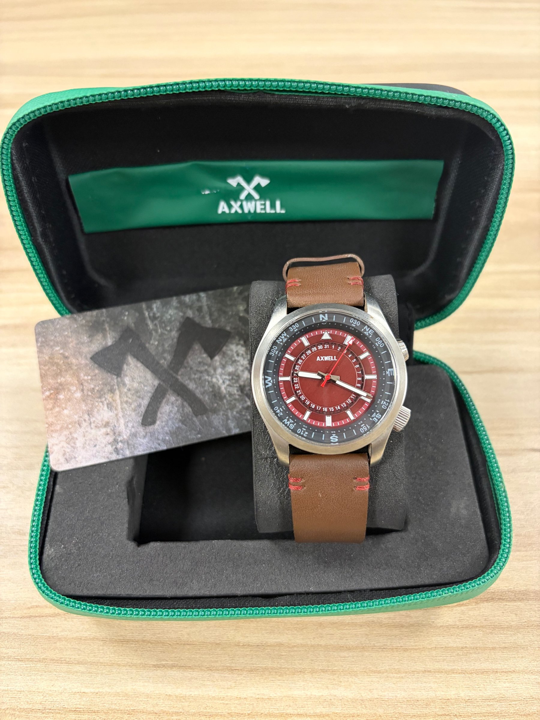 Axwell World Compass Adventurer watch in box with brand card, red dial and compass bezel detail