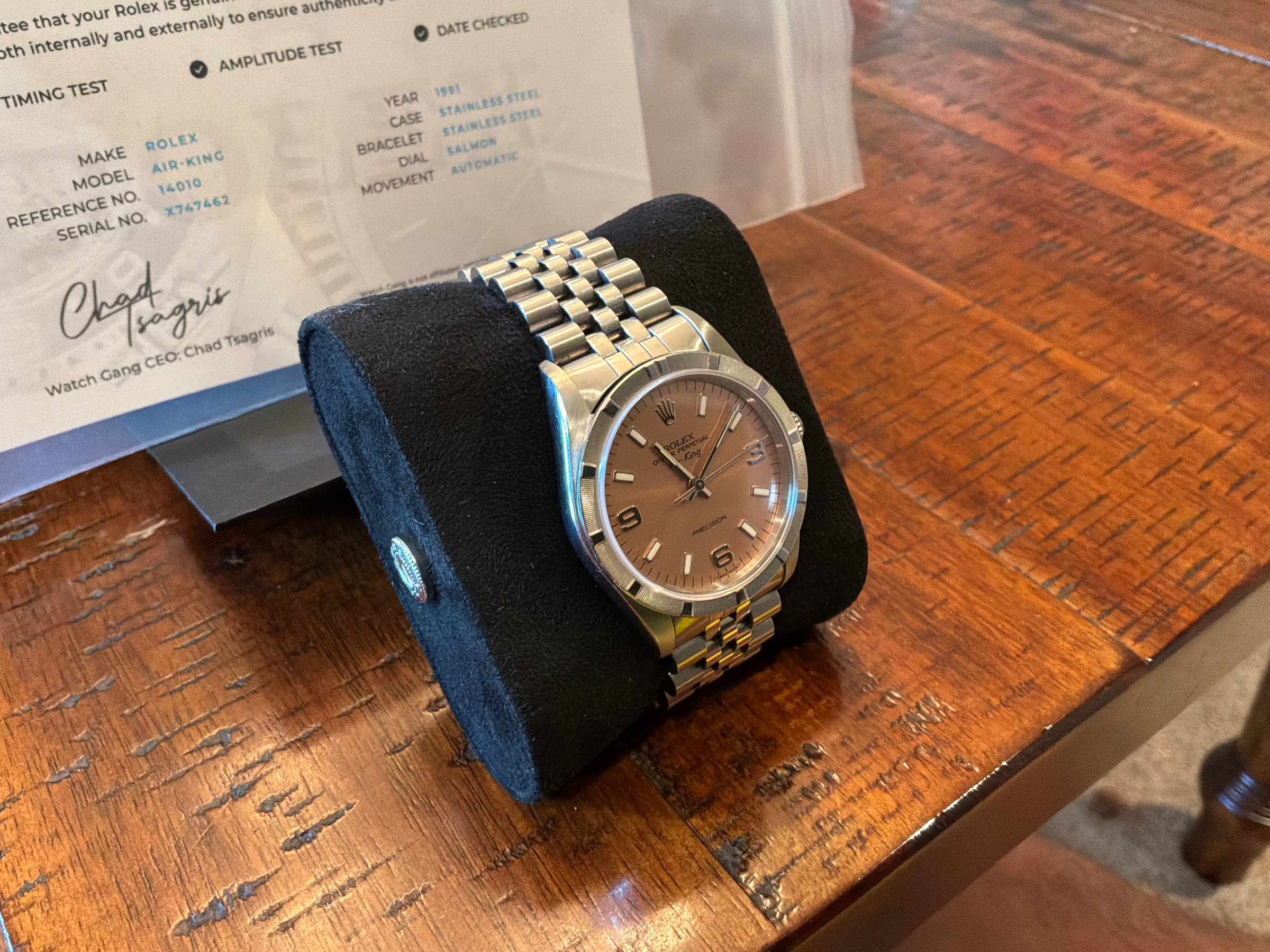1991 Rolex Air-King Ref. 14010 with salmon dial on display stand, Watch Gang authenticity certificate in background