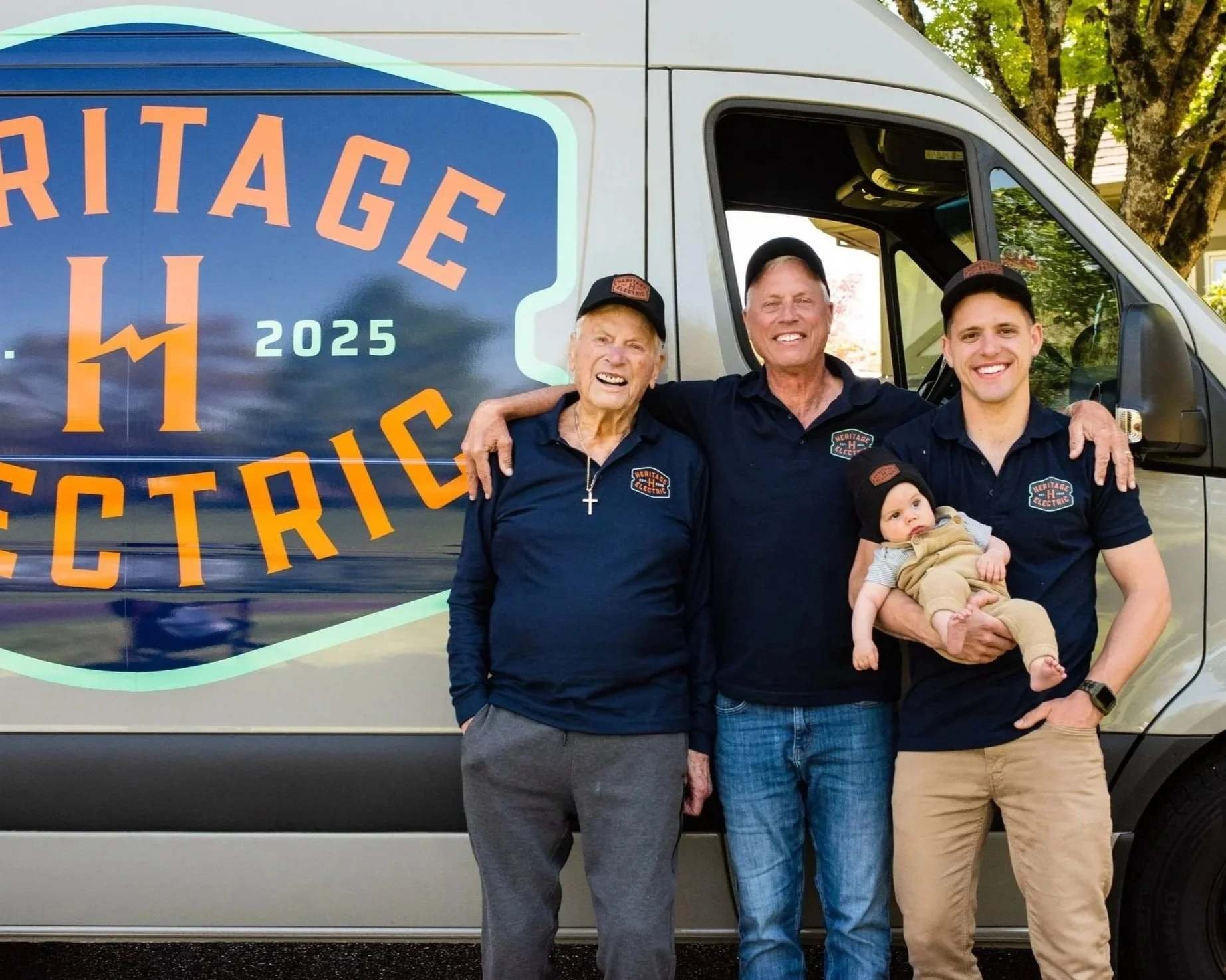 Three generations of the Heritage Electric family standing in front of their service van