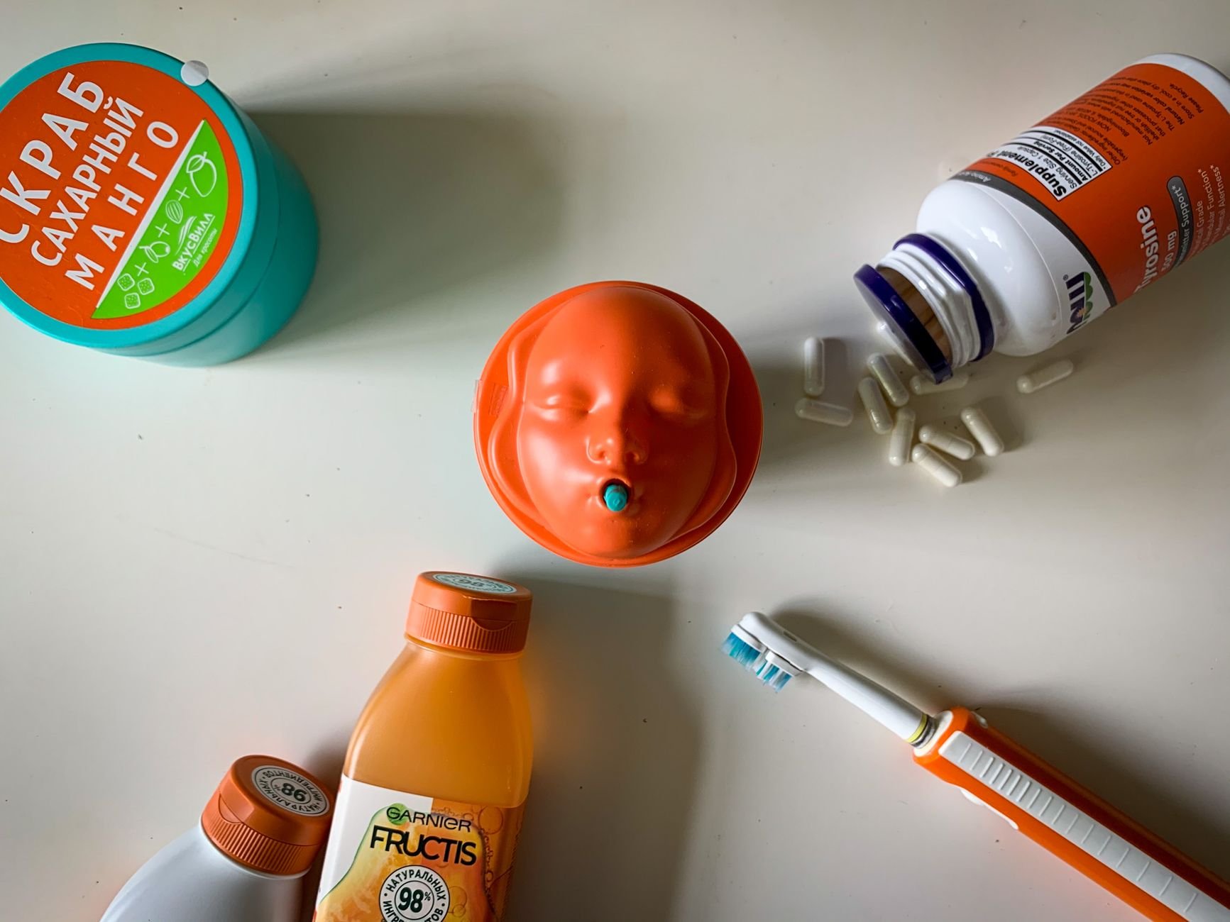 A creative flat lay composition featuring beauty products and supplement bottles on a white surface.