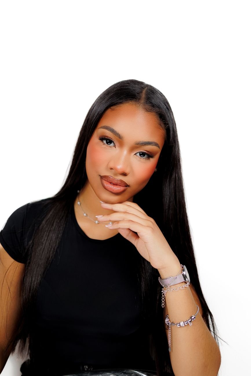 Close-up portrait of a confident woman with sleek long hair, wearing elegant jewelry.