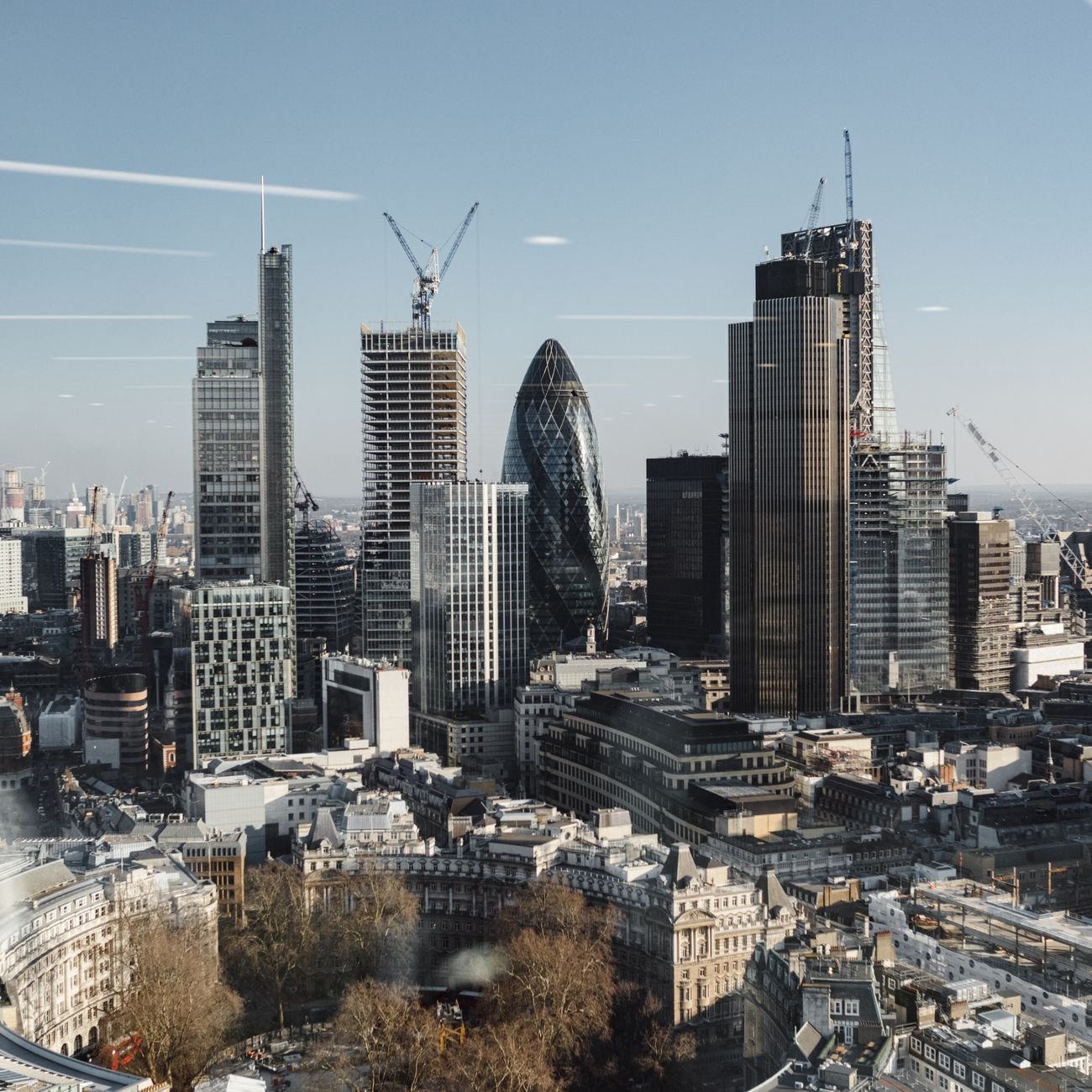Picturesque drone view of London streets and complex of commercial skyscrapers under blue sky in financial district