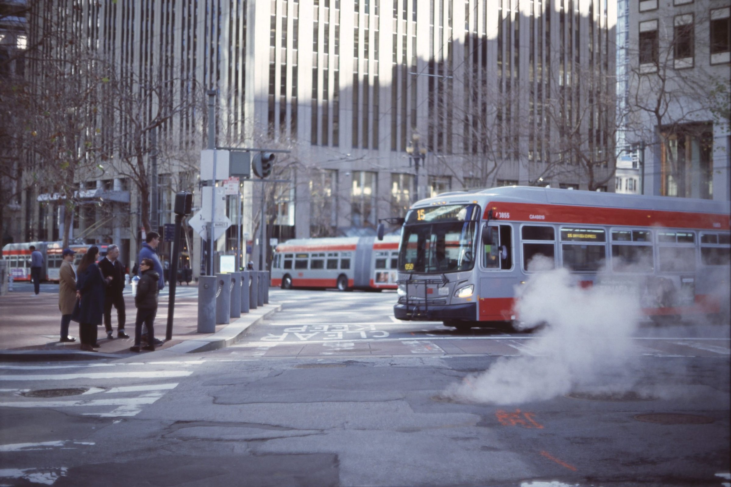 San Francisco MUNI buses on a city street with steam rising, film photograph