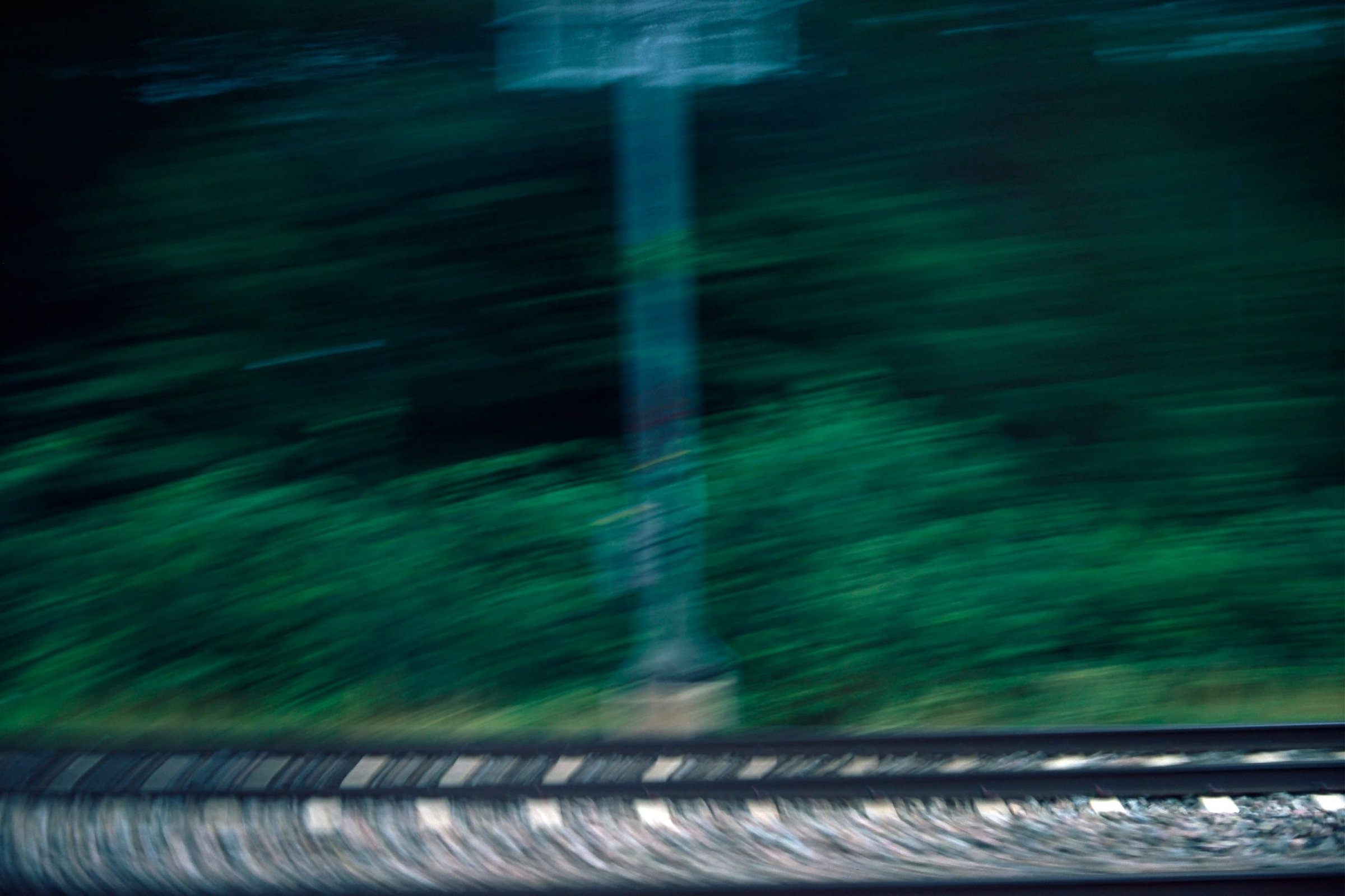 Train tracks receding into blurred motion, film photograph