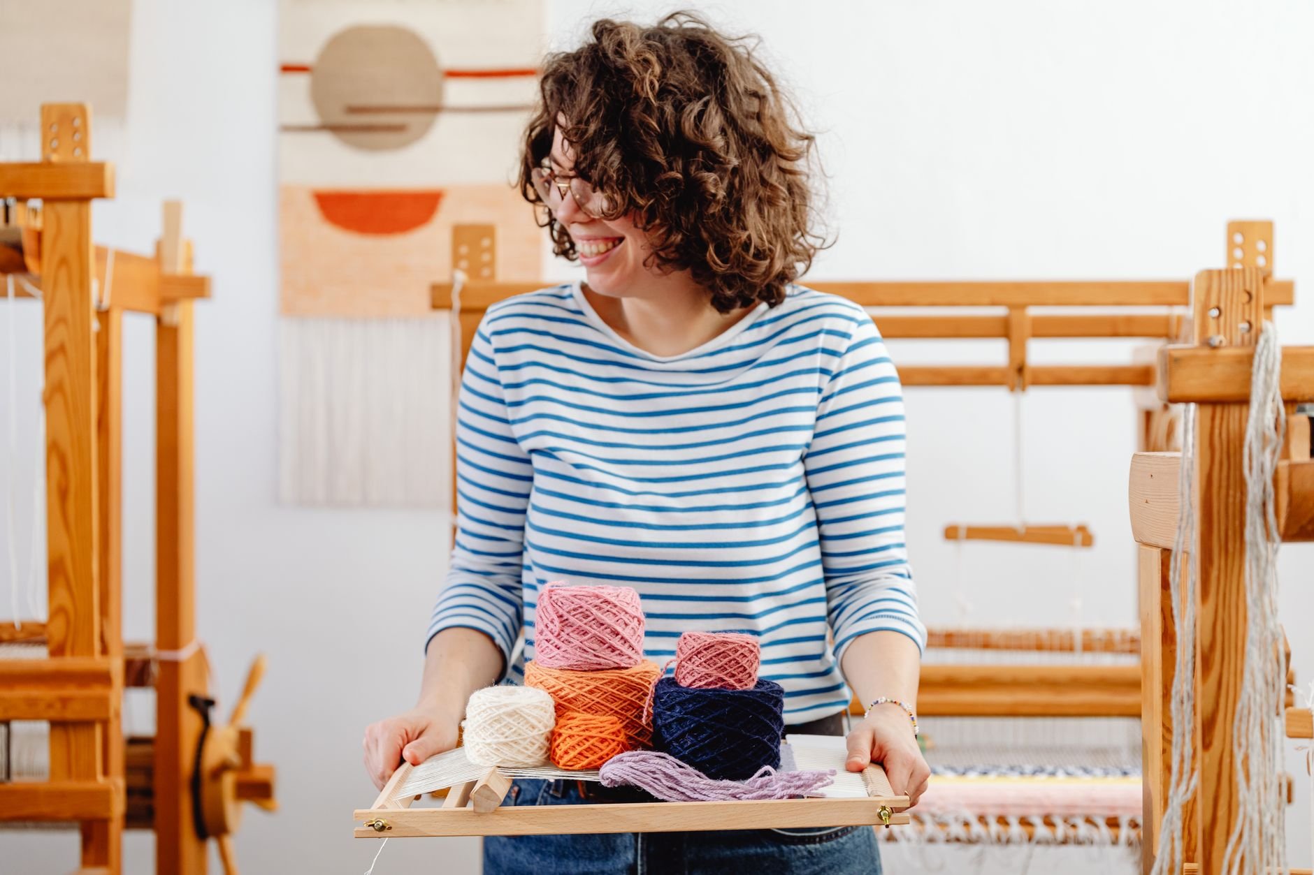 A woman joyfully working in a colorful craft studio