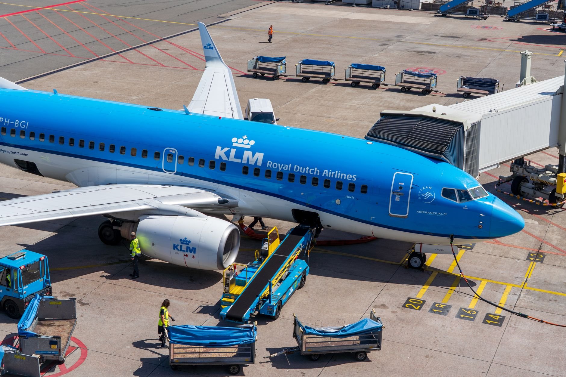 KLM airline ground crew servicing an aircraft at the terminal — diverse airport operations team.