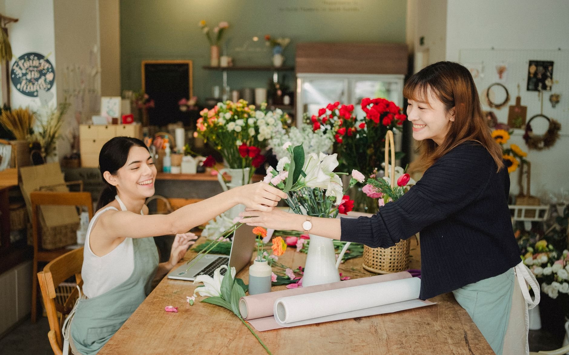 Small business owner working in floral shop with laptop