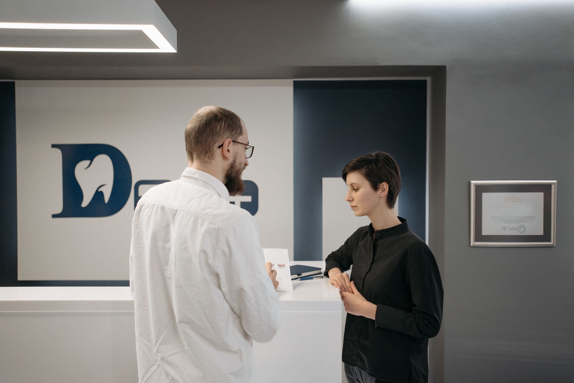 Dentist consulting patient at modern dental clinic