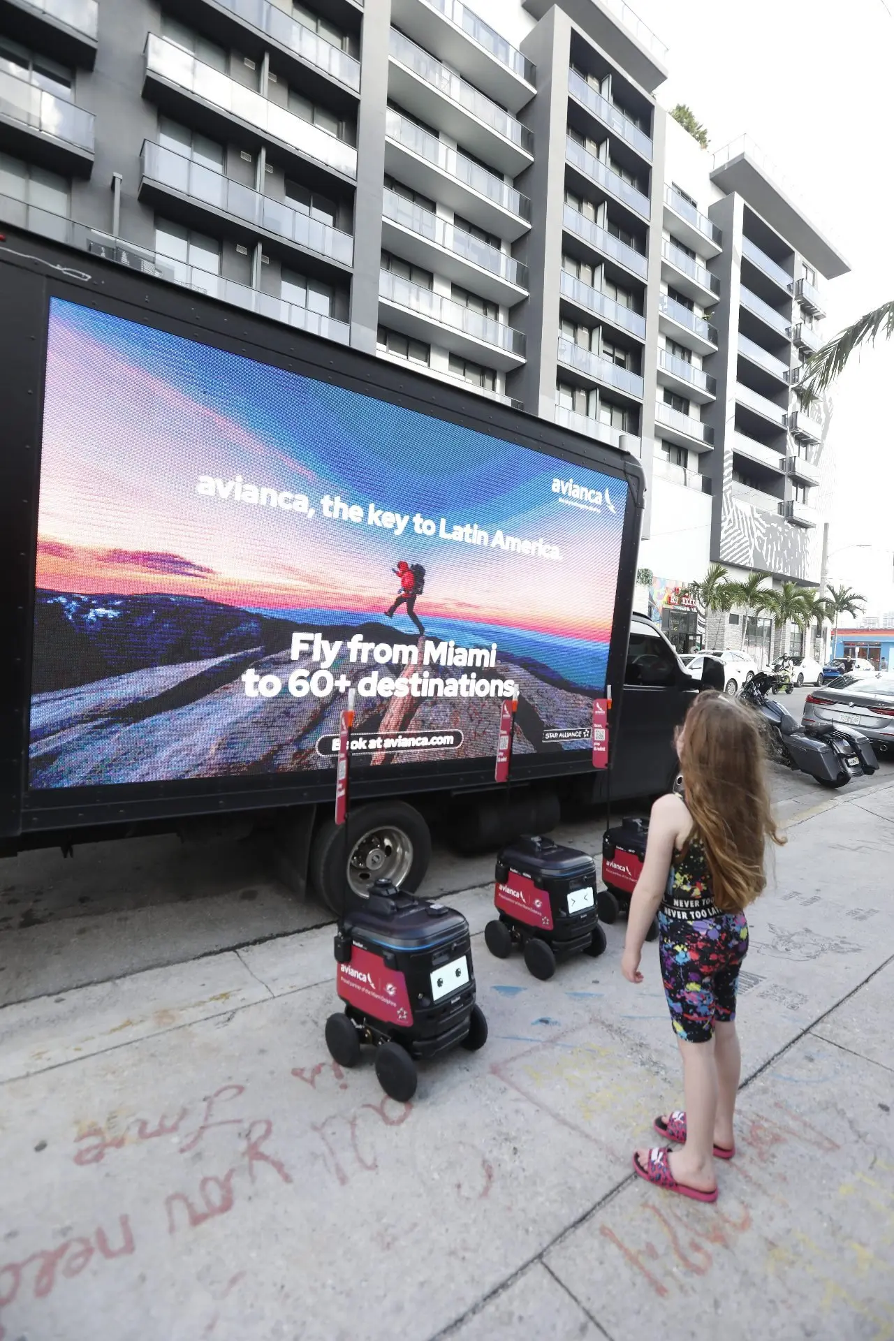 Child watching branded robot and LED truck in Miami