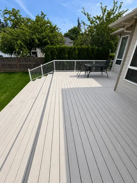 Light grey composite deck with white metal railing and outdoor dining area, Portland Oregon