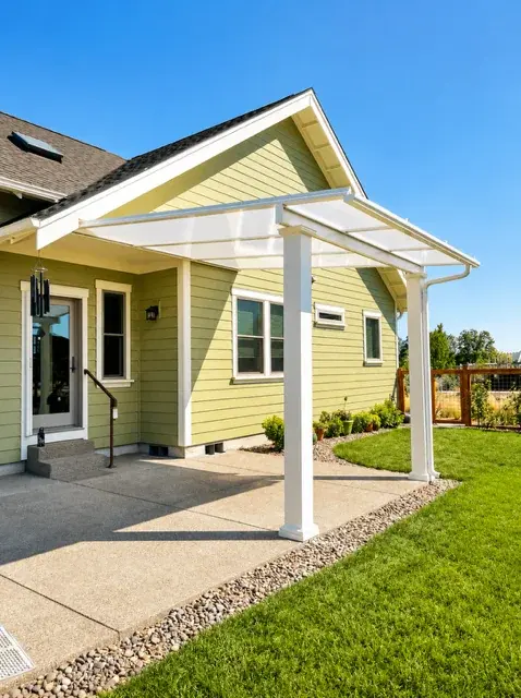 Covered patio addition with polycarbonate roof on craftsman home