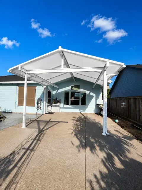 Modern white carport pergola cover with clean architectural lines and concrete driveway