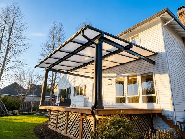 Modern dark frame pergola attached to home with backyard views